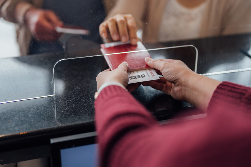 Passenger handing off passport and other legal documents in border security check