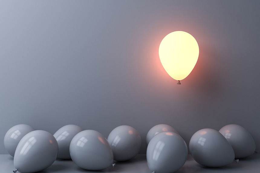 image: one balloon lit up floating above gray balloons