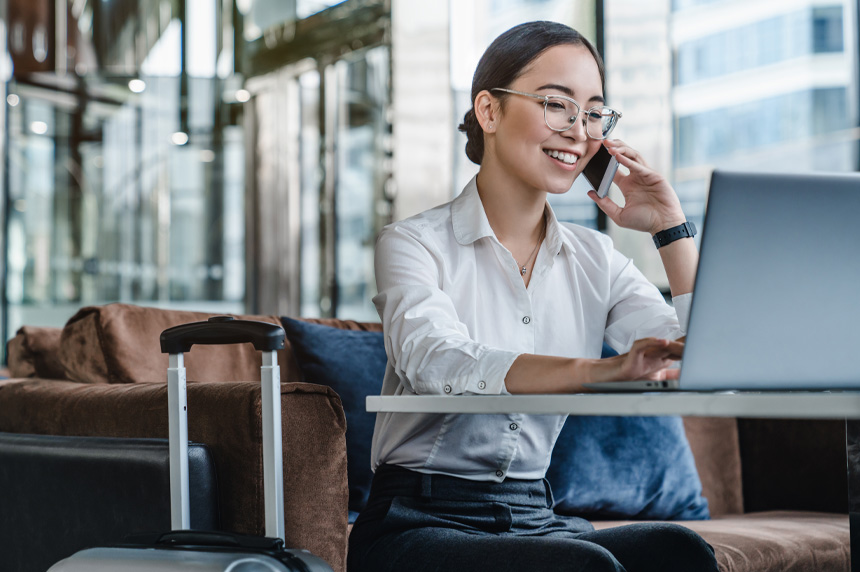 Woman talking on the phone while using her laptop